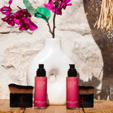 a photo of the attention seeker shimmer oil and body applicator brush in the sun with a vase behind