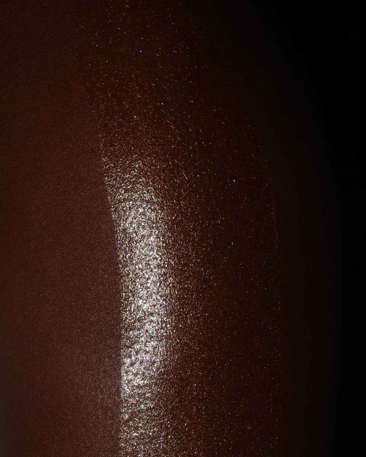 a photo showing the results of the attention seeker shimmer oil on black skin. the best shimmer oil for bronzing, glitter, shine and glow