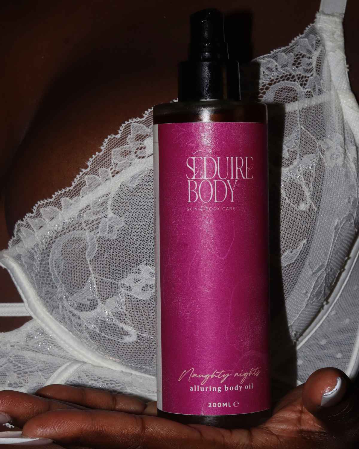 a photo of the seduire body naughty nights natural fragrance free body oil for dry and sensitive eczema prone skin being held in a womans hand