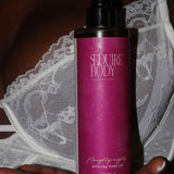 a photo of the seduire body naughty nights natural fragrance free body oil for dry and sensitive eczema prone skin being held in a womans hand