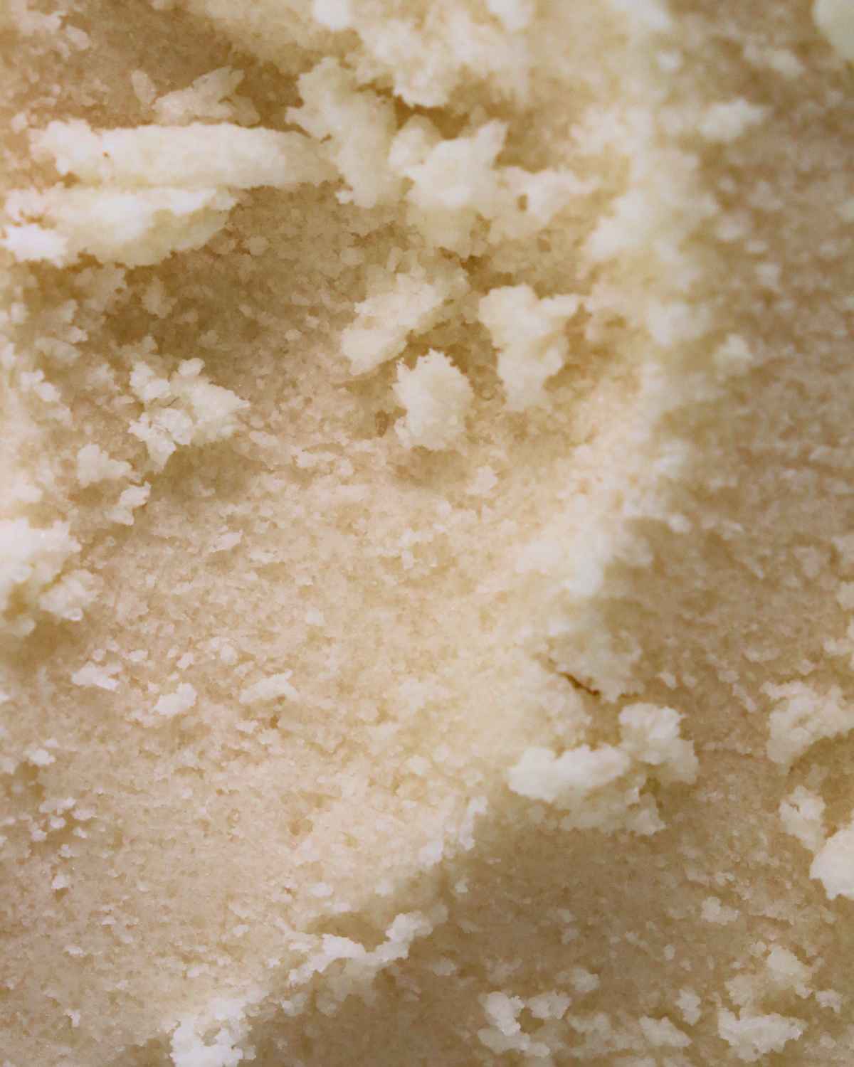 a close up texture shot of our vanilla scented body scrub for body acne, hyperpigmentation, dull skin, strawberry legs and clogged pores