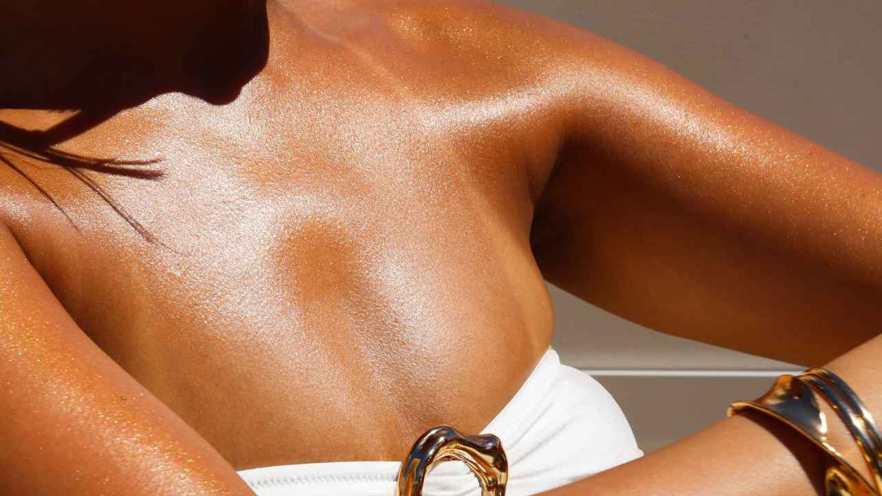 a photo of a womans arm showing the golden body shimmer oil results after application using a body applicator brush